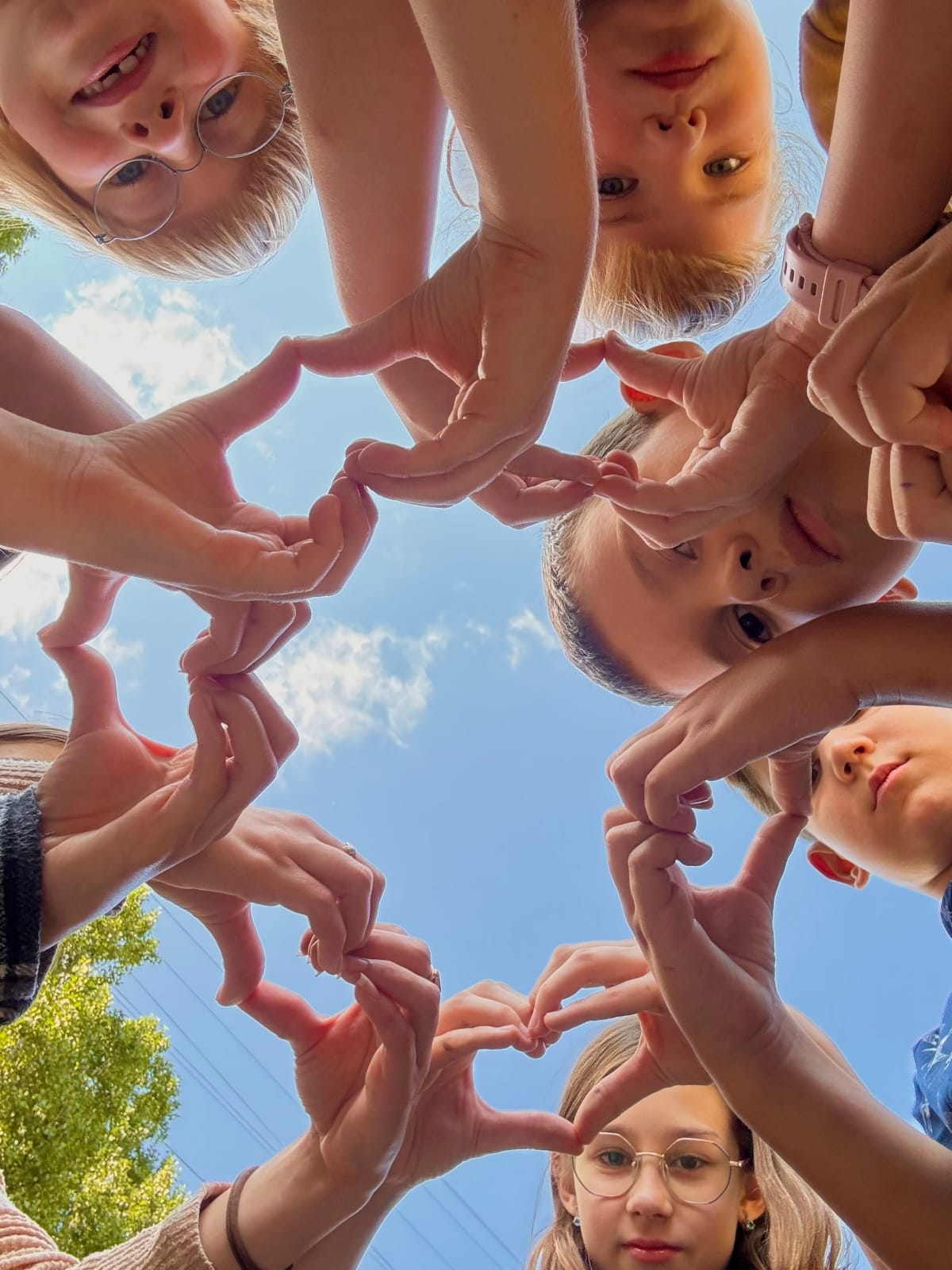 Сердечки руками на фоне неба