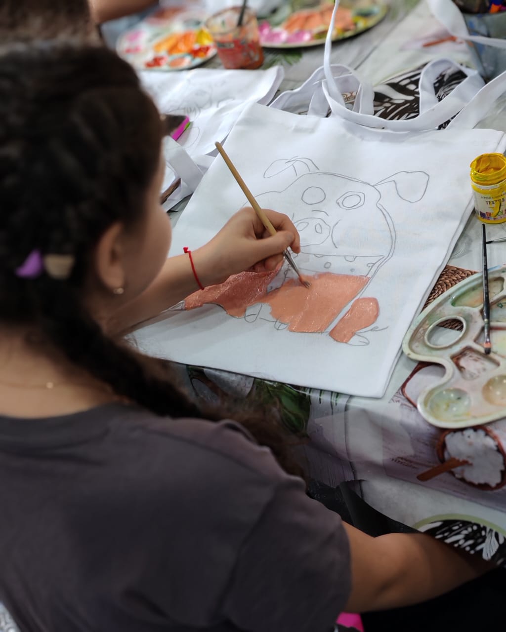 Девочка рисует на сумке