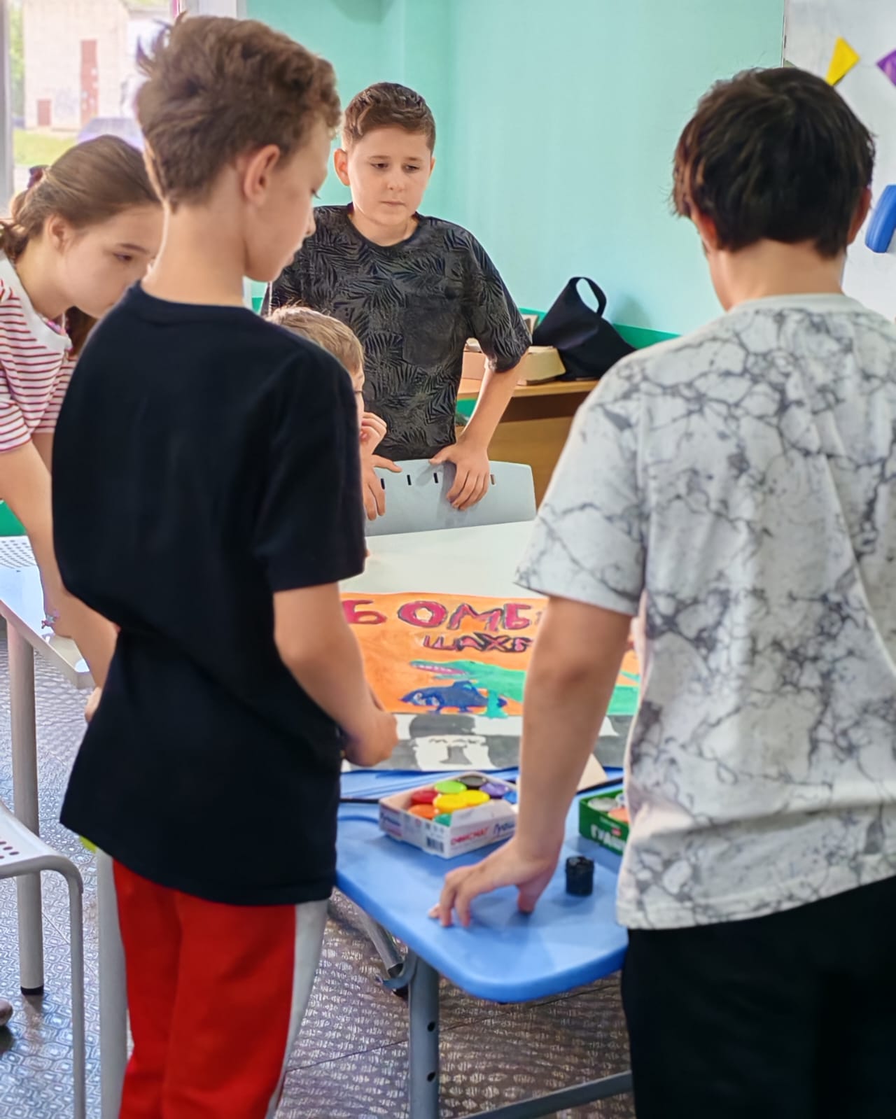 Дети за столом с красками